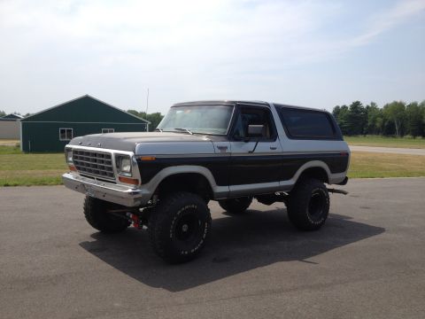 1979 Ford Bronco - This lifted 1979 Ford Bronco features a two-tone paint scheme and is captured from a 3/4 front angle.