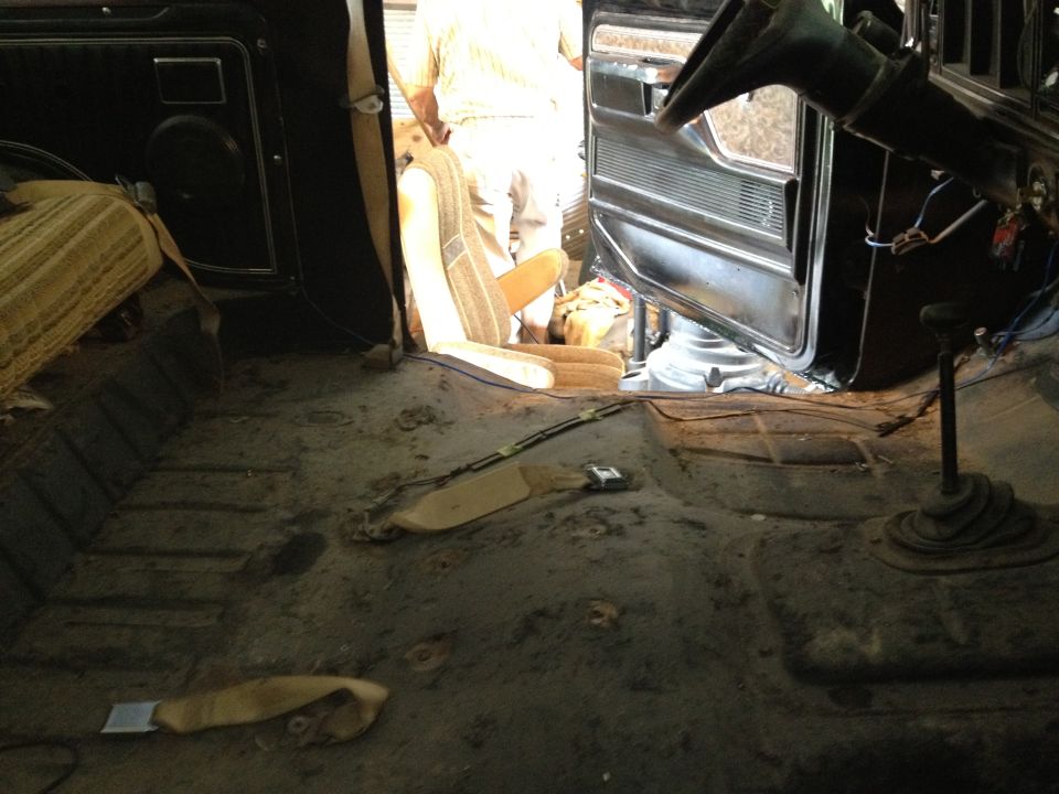 Interior view of a vehicle with seats removed, showing floor and door panel. Appears to be a 1978 Ford Bronco