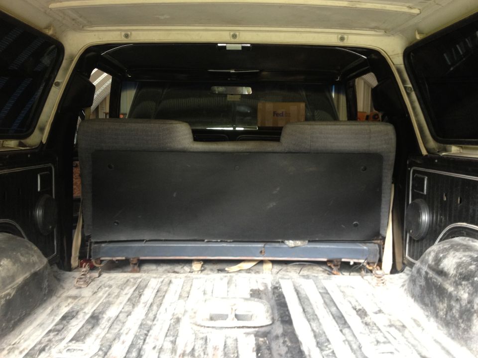 Interior cargo area of a light-colored SUV with a folded rear seat and a FedEx box visible through the rear window