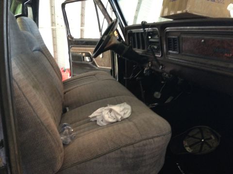 1979 Ford Bronco - The interior of a truck shows a bench seat, steering wheel, and dashboard with vents.