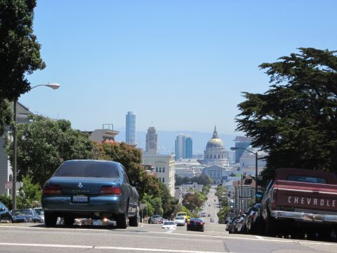 1991 Ford LTD Crown Victoria - View of downtown San Francisco from a residential street, showing traffic and iconic buildings.