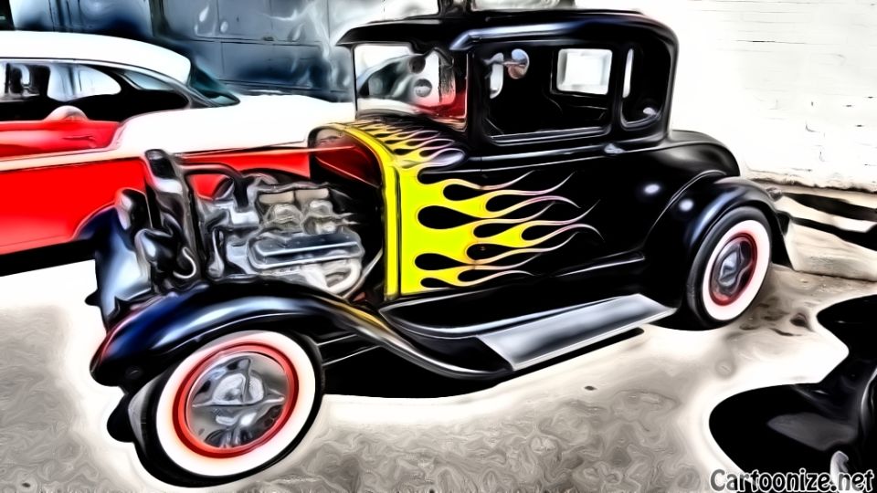 black hot rod coupe with yellow and red flames, red and white tires, parked next to a red and white car