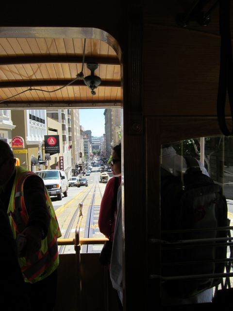 1991 Ford LTD Crown Victoria - View of a busy San Francisco street with cable car tracks, traffic, and buildings, seen from inside a cable car.