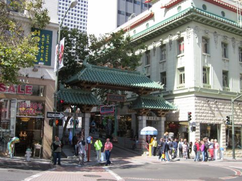 1991 Ford LTD Crown Victoria - A busy street scene unfolds in Chinatown, traditional architecture and a crowd of pedestrians.