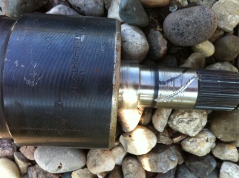 1995 Ford Probe - A driveshaft part with visible markings rests on a bed of rocks.