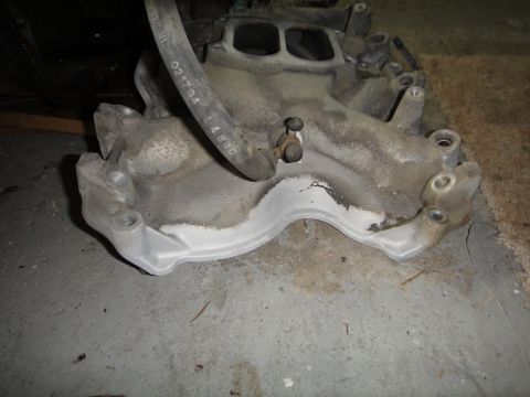 1994 Ford Bronco - Close-up of an intake manifold with a hose attached, a visible part number and the SuperMotors.net logo.