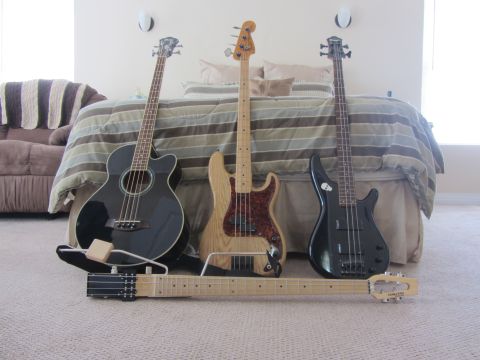 1968 Ford Mustang - Collection of bass guitars and a guitar neck displayed in a bedroom setting.