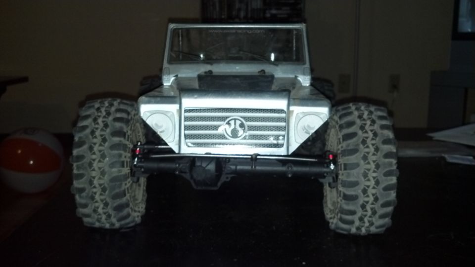 RC rock crawler truck with large tires and a silver body, front view