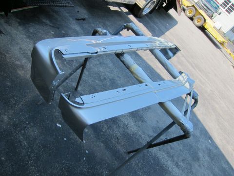 1991 Ford LTD Crown Victoria - A car bumper is being worked on, with other vehicles visible in the background.