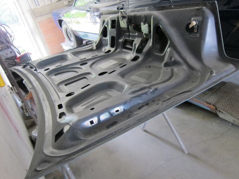 1991 Ford LTD Crown Victoria - The underside of a car hood is visible, with a blue car in the background.