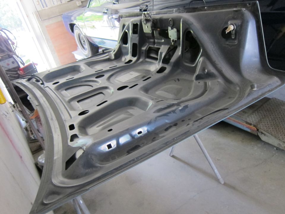 Car hood interior, gray, angled view, showing latch mechanism and bracing
