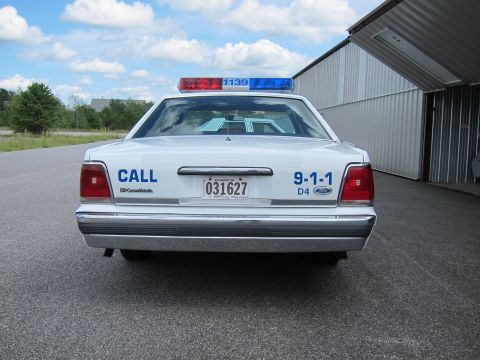 1991 Ford LTD Crown Victoria - Rear view of a 1991 Ford Crown Victoria LTD police car, showing the light bar and markings.