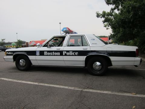 1991 Ford LTD Crown Victoria - A Boston Police car is parked in a lot, showing its side profile and police markings.