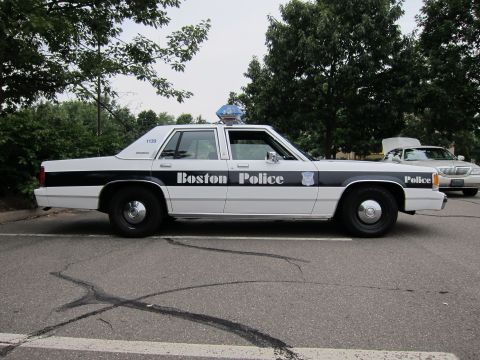 1991 Ford LTD Crown Victoria - A 1991 Ford Crown Victoria LTD police car is parked on asphalt, with another car visible in the background.