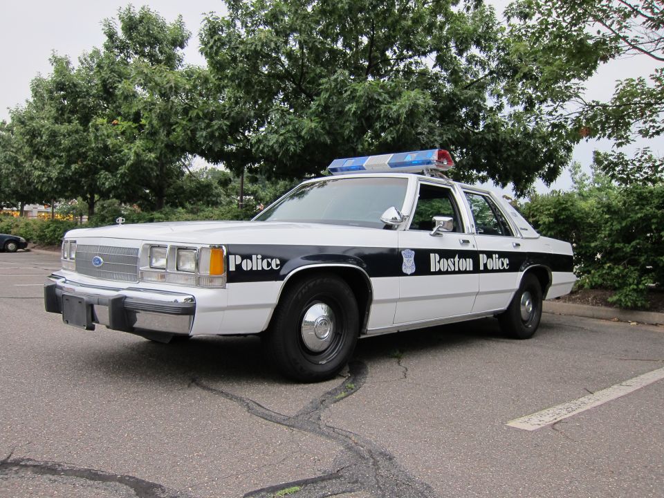 Boston Police car, white with black stripe and 'Boston Police' text. Light bar on top