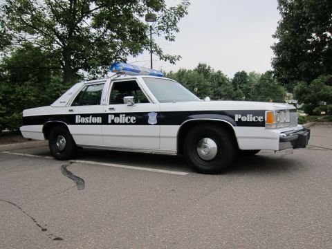 1991 Ford LTD Crown Victoria - A Boston Police car is parked in a lot, showing its side profile and markings.