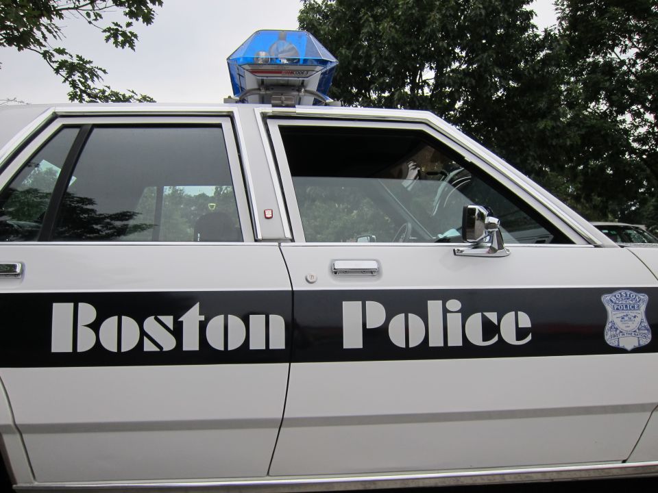 Side view of a Boston Police car with 'Boston Police' written on the door and a police badge