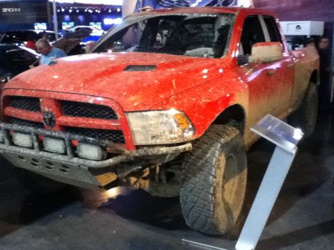 1990 Ford Bronco - This red pickup truck appears to be modified for off-road use and is covered in mud.