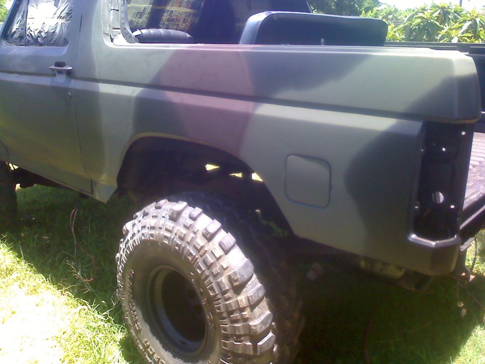 Camouflaged SUV side view with large off-road tires