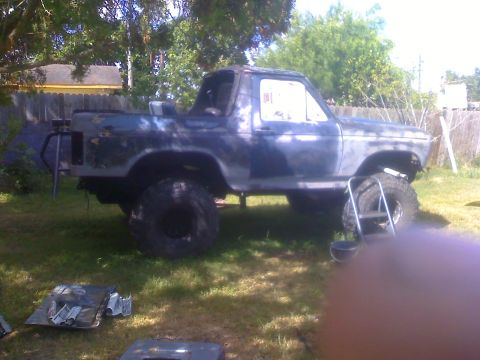 1990 Ford Bronco - This Ford Bronco appears to be undergoing modifications or repairs in a grassy outdoor area.