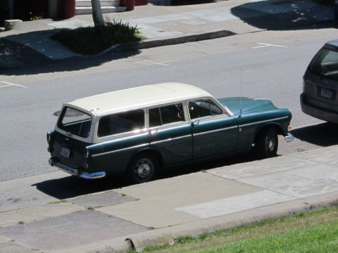 1991 Ford LTD Crown Victoria - A vintage station wagon is parked curbside on a sunny day, with another vehicle nearby.