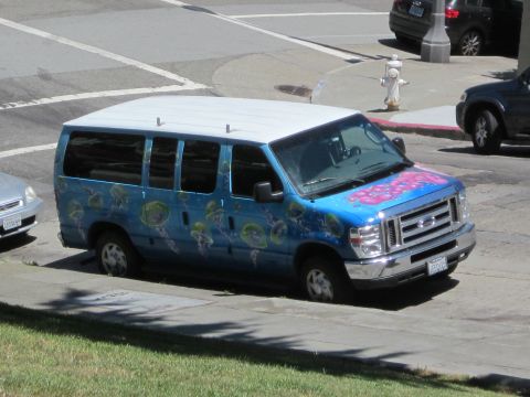 1991 Ford LTD Crown Victoria - A blue van with a white roof and a colorful jellyfish mural is parked on the side of the road.