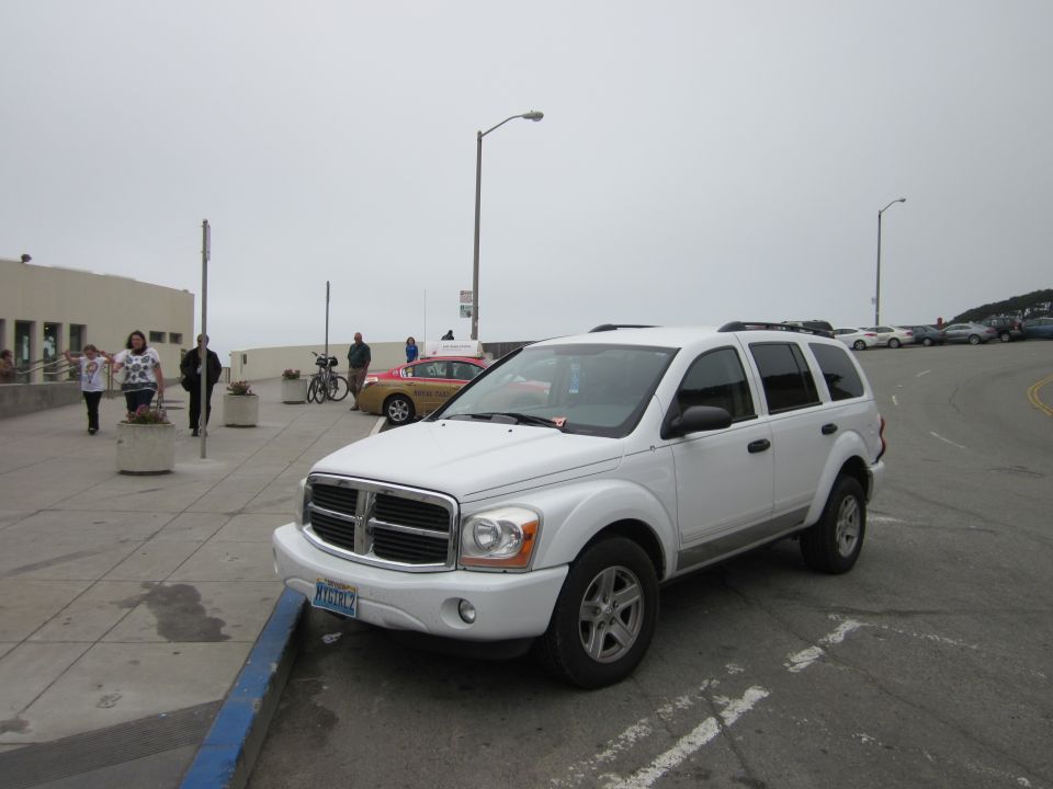 White Dodge Durango SUV parked on a street with a blue curb