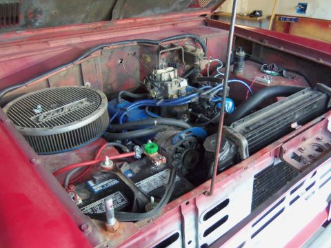 1968 Ford Bronco - Engine bay of a red 1968 Ford Bronco, an Edelbrock air cleaner and V8 engine components.
