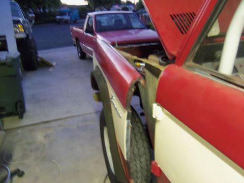 1968 Ford Bronco - A red and white SUV is parked in a driveway, with its hood up, next to a red pickup truck.