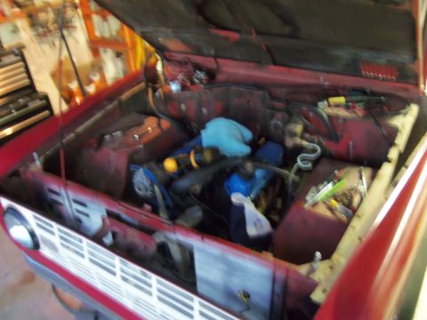 1968 Ford Bronco - Engine bay view of a red 1968 Ford Bronco, showing the engine and surrounding components with the hood raised.