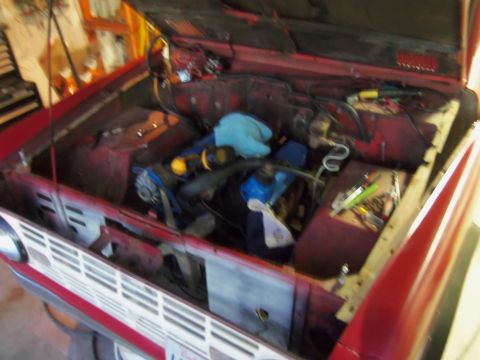 1968 Ford Bronco - Engine bay of a 1968 Ford Bronco, with the hood open, revealing the engine and surrounding parts.