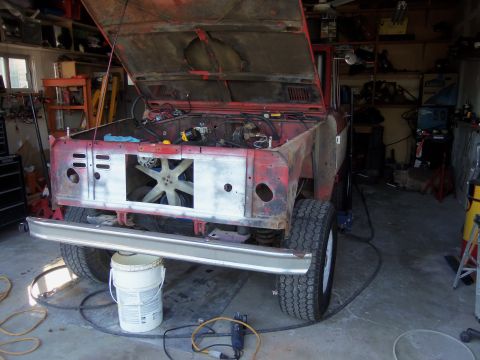 1968 Ford Bronco - This 1968 Ford Bronco is in a garage with its hood open, revealing the engine and a damaged front end.