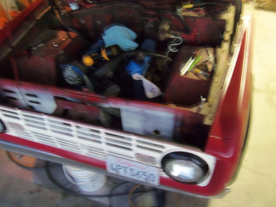 1968 Ford Bronco engine bay with tools and parts scattered around