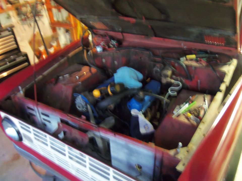 1968 Ford Bronco engine bay with hood open, showing engine components and tools