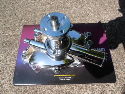 1990 Ford Bronco - A shiny chrome water pump sits on a product box, likely for sale or display.