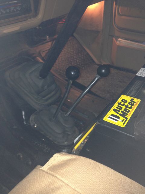 1984 Ford Bronco - Interior view of a vehicle's center console with dual shifters and an Auto Meter sticker.