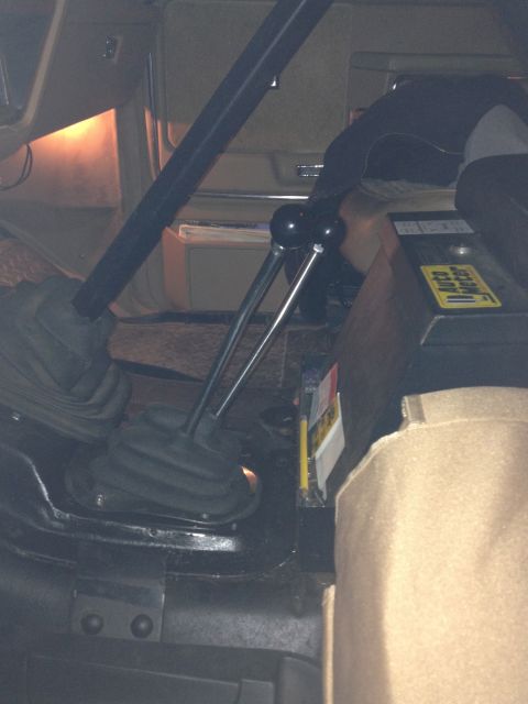1984 Ford Bronco - The interior of the vehicle shows a dual shifter setup and an Auto Meter gauge mounted on the console.