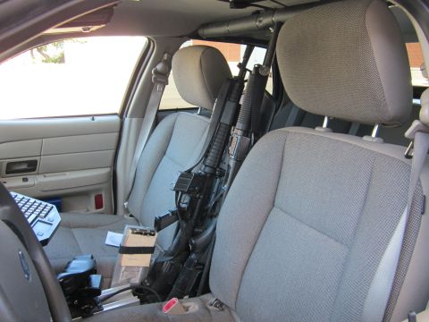 1991 Ford LTD Crown Victoria - Rifles are secured between the front seats of a police vehicle.