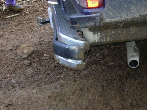 1991 Ford Bronco - The rear bumper and exhaust pipe of a vehicle are visible, covered in mud.