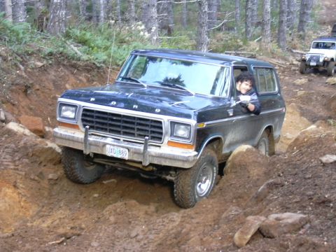 1991 Ford Bronco - Ford Bronco tackling a challenging muddy terrain with another vehicle following.