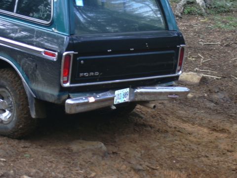 1991 Ford Bronco - The rear of a Ford Bronco is shown on a muddy, off-road path.