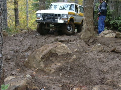 1991 Ford Bronco - Ford Bronco tackling a challenging off-road course in a wooded area.