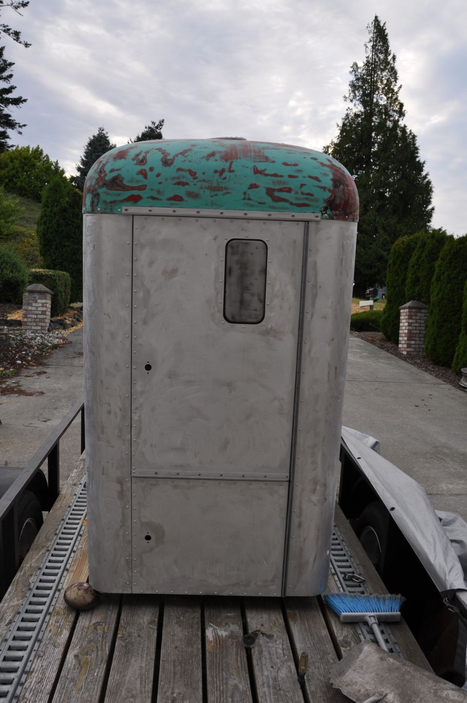 1959 Kenworth W900A truck cab, unpainted aluminum body, green and red weathered roof, on a trailer
