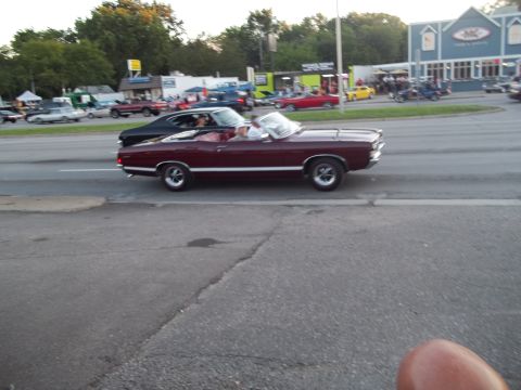 1970 Ford Ranchero - Maroon convertible cruises down the street with another car following closely behind.