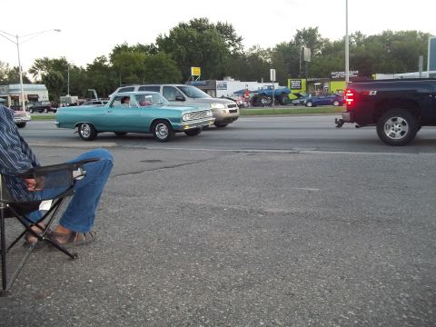 1970 Ford Ranchero - A light blue 1964 Ford Ranchero is seen driving on a road, with other vehicles and a person in a chair nearby.