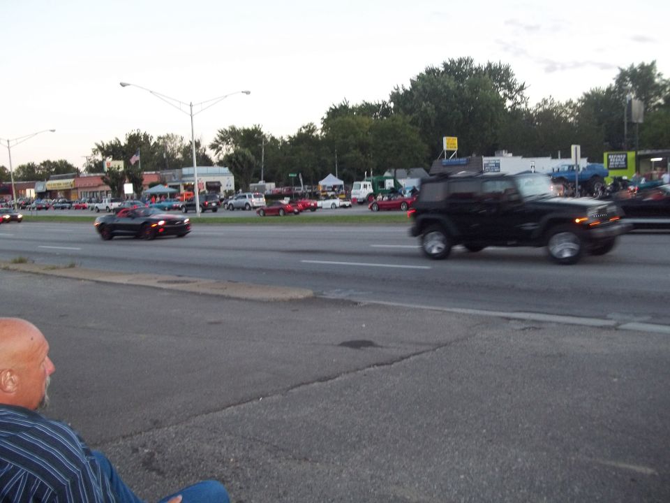 Black Jeep Wrangler driving on a road, side view
