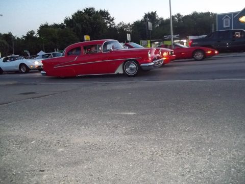1970 Ford Ranchero - A red 1955 Chevrolet sedan drives down the road alongside other vehicles.