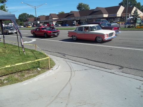 1970 Ford Ranchero - Two classic cars cruise down a suburban street on a sunny day.
