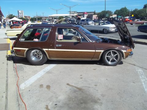 1970 Ford Ranchero - This brown station wagon features wood paneling and custom wheels, with its hood open.