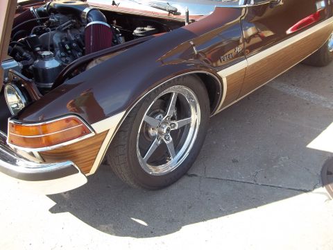 1970 Ford Ranchero - A customized car with wood paneling and a prominent engine is shown from the front quarter view.